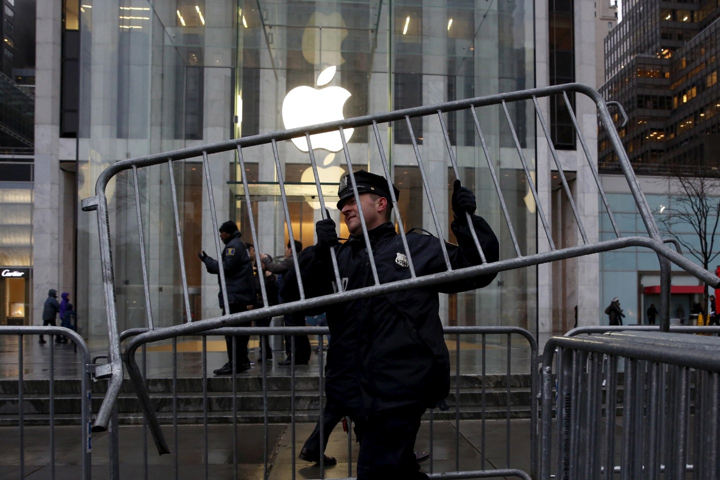 A NYPD officer carries a barrier outside the Apple Store in New York
