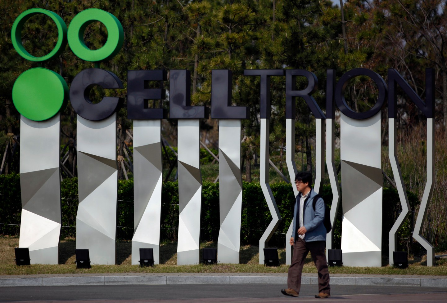 Man walks past a logo of Celltrion Inc in front of the plant in Incheon