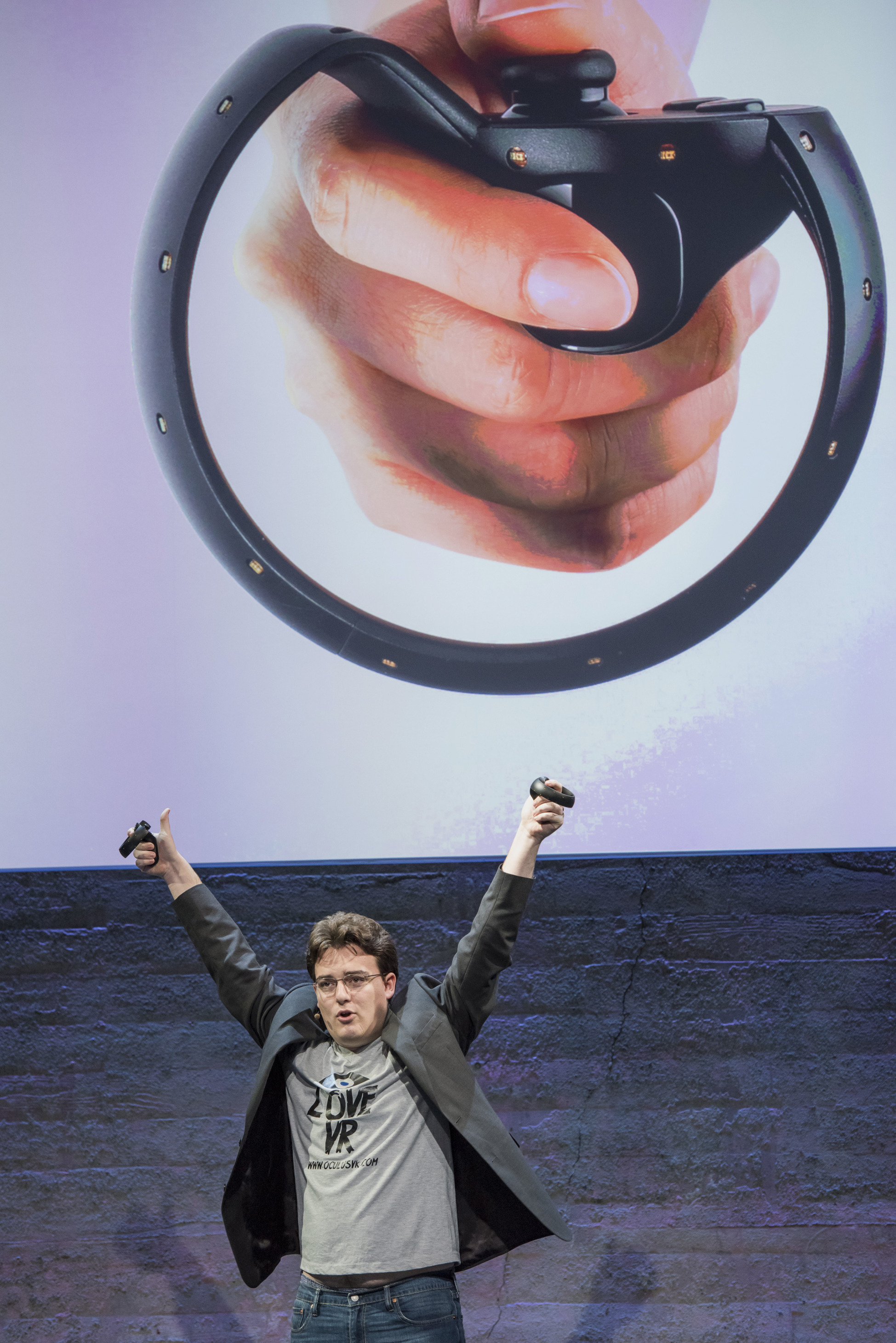 Palmer Luckey, co-founder of Oculus VR. Inc. and creator of the Oculus Rift, holds up the Oculus Touch controller as he speaks during the Oculus VR Inc. "Step Into The Rift" event in San Francisco,   California, U.S., on Thursday, June 11, 2015. Facebook Inc.'s Oculus virtual-reality headsets will work with Microsoft Corp.'s Windows 10 and use the software maker's wireless Xbox game controller. Photographer: David Paul Morris/Bloomberg  *** Local Caption *** Palmer Luckey