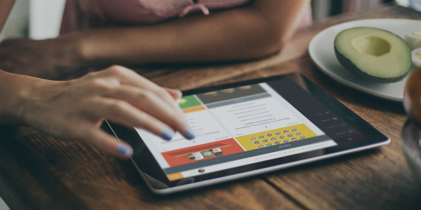 Caucasian Woman Reading on Her Tablet While Having Breakfast