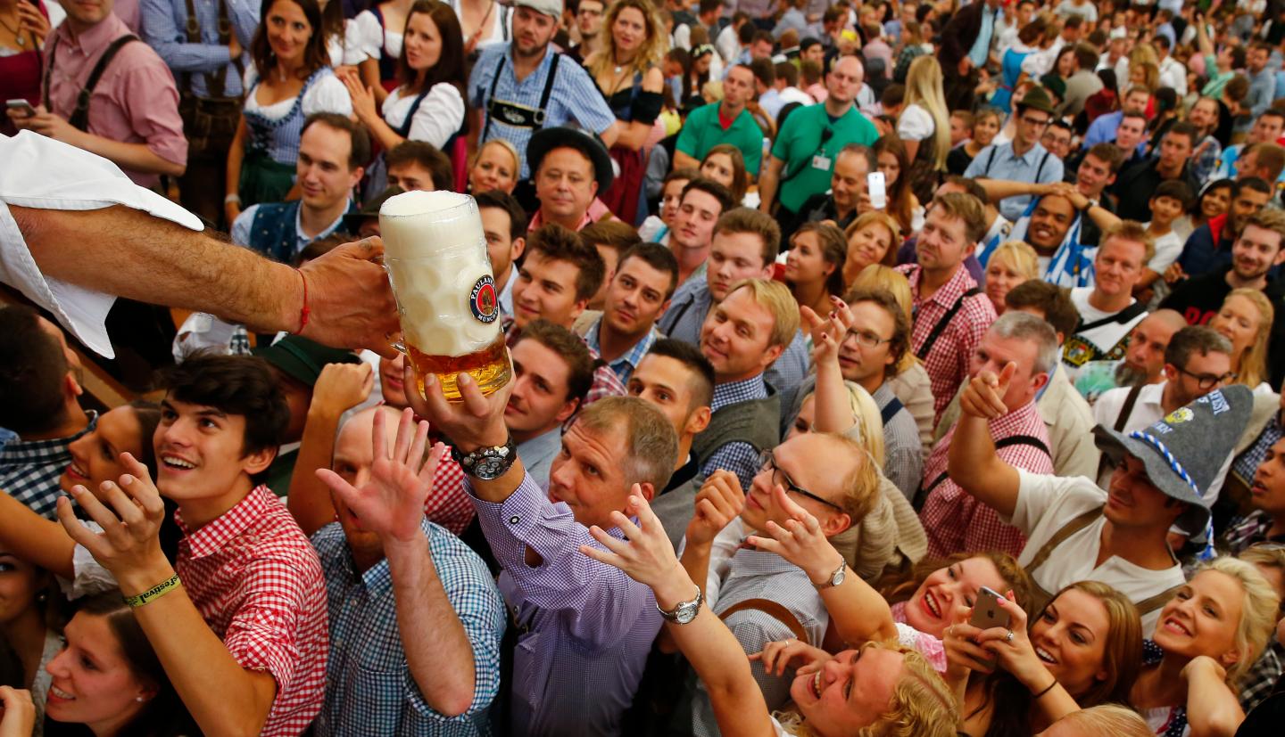 Visitors reach for one of the mugs of beer from the first barrel during the opening ceremony for the 182nd Oktoberfest in Munich