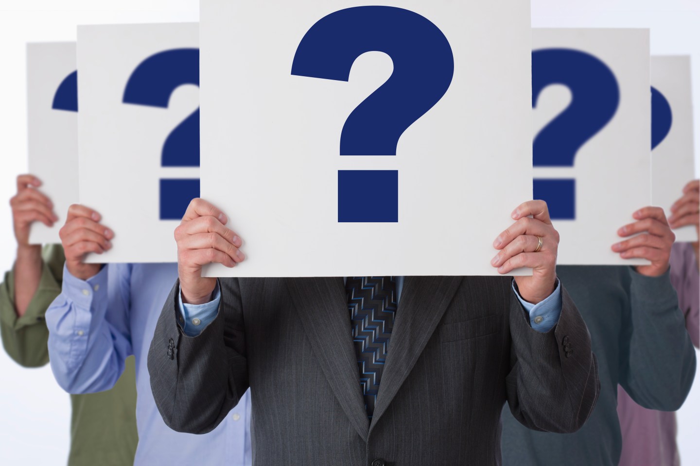 Multiplied businessman standing with question marks in fron of his face