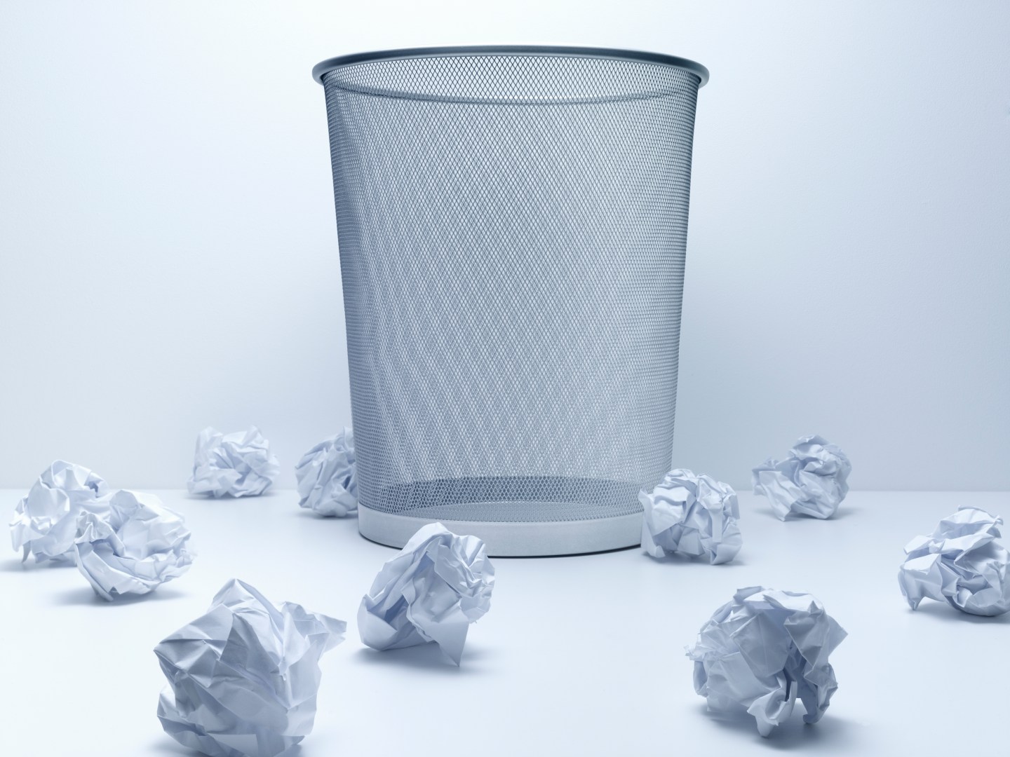 Crumpled balls of paper beside wastebasket