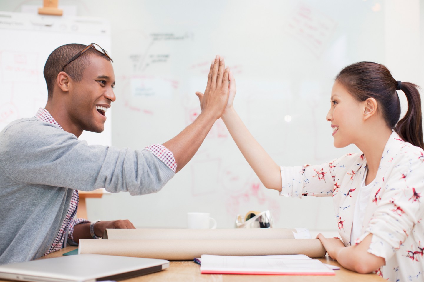 Business people high fiving in office