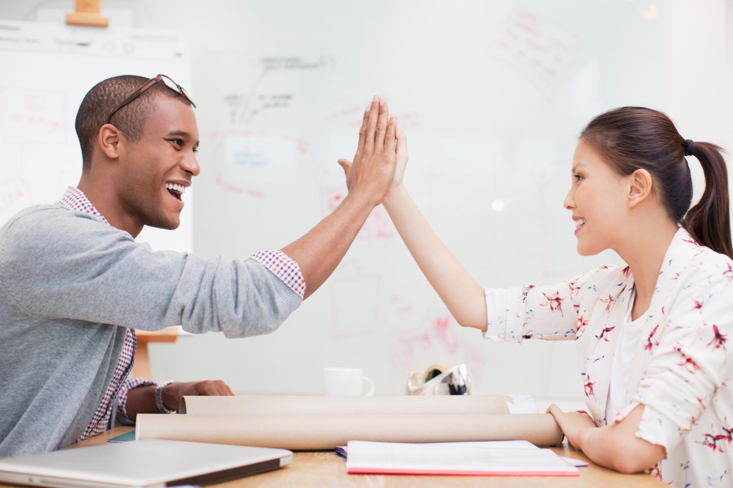 Business people high fiving in office
