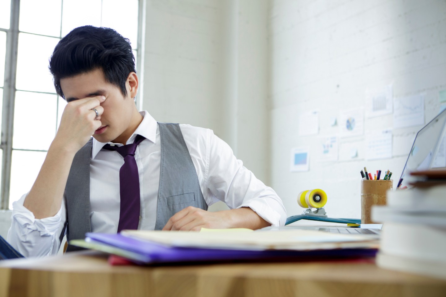 Stressed young man sitting at office desk