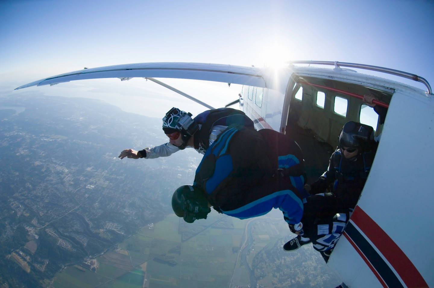 Two skydivers jumping out of airplane, aerial view
