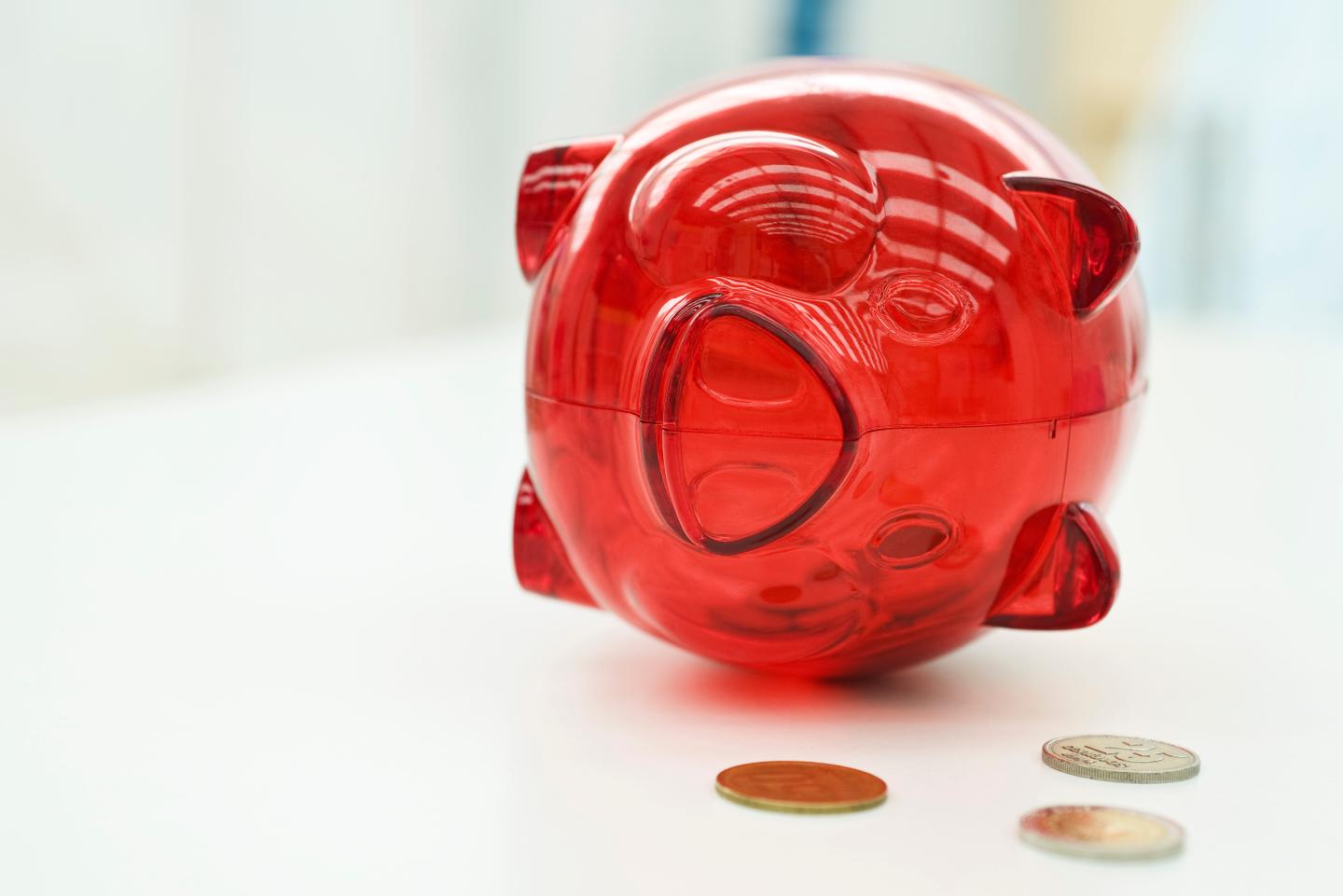 Piggy bank lying on side, coins nearby