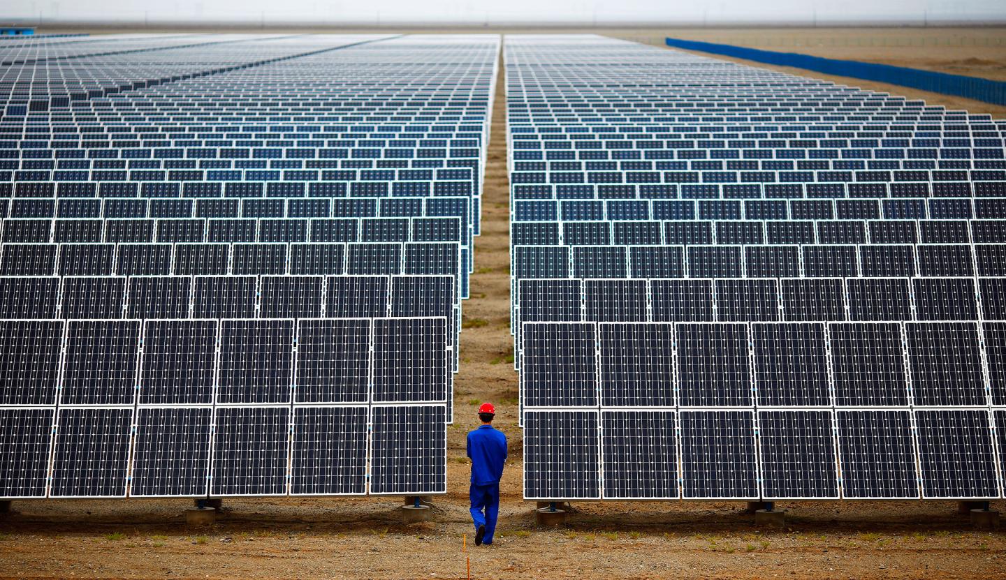 A worker inspects solar panels at a solar farm in Dunhuang, 950km northwest of Lanzhou, Gansu Province
