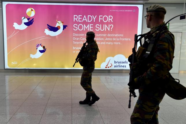 Soldiers walk in the departure hall after a ceremony at Brussels Airport as it reopens 40 days after deadly attacks in Zaventem