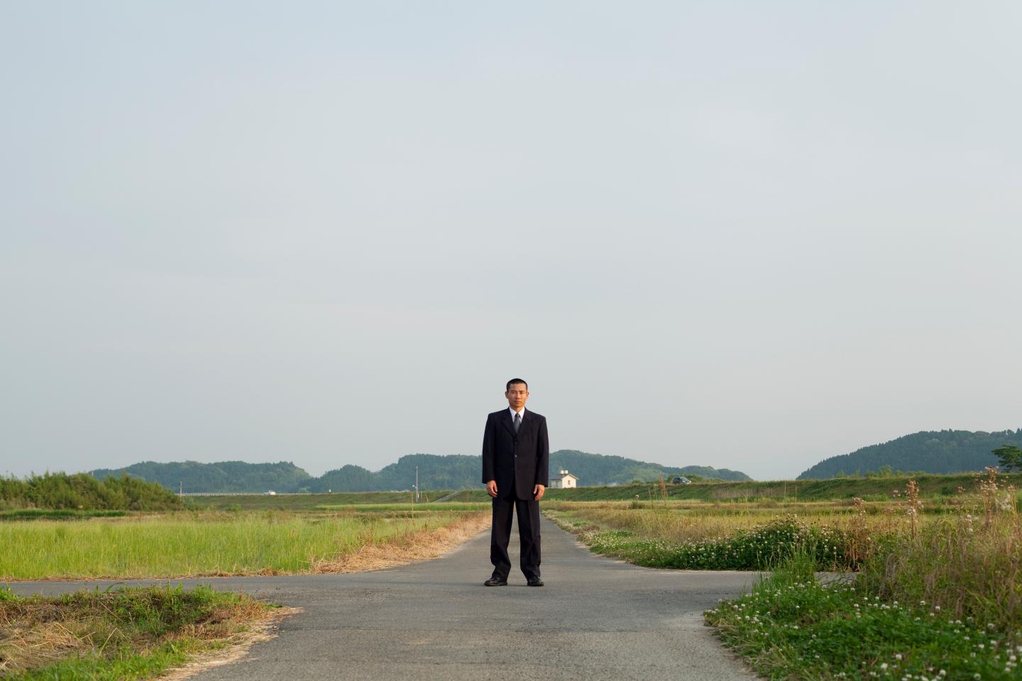 A businessman standing on the country road.