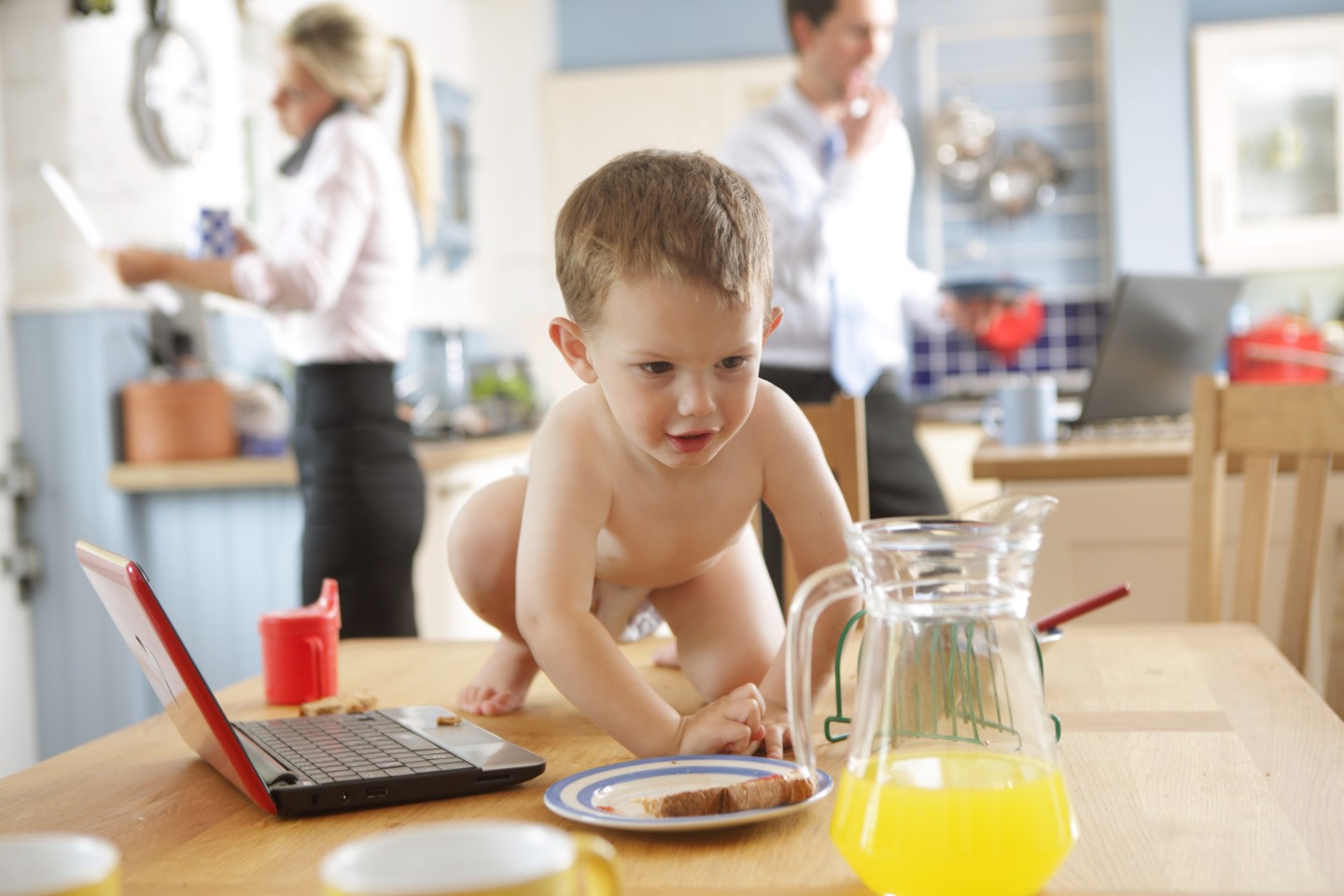 Toddler on table, distracted working parents