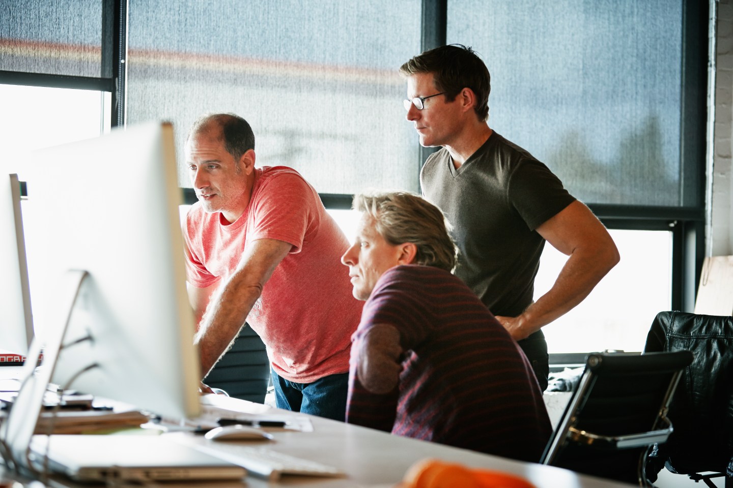 Businessmen at computer in startup office
