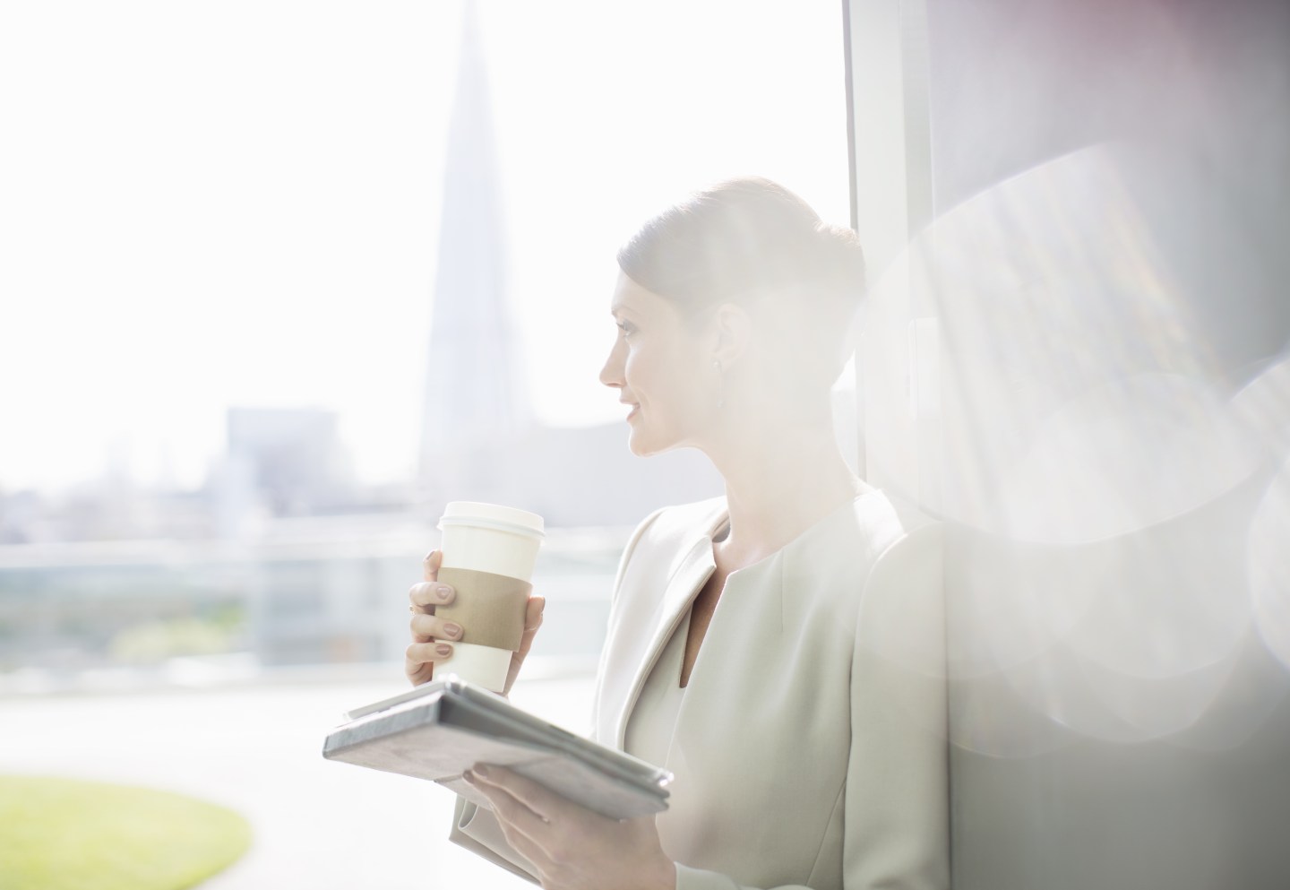 Businesswoman enjoying cup of coffee at window