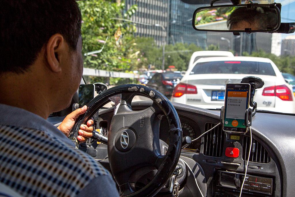 BEIJING, CHINA - 2015/08/04: A taxi driver is using Didi Dacha App while driving on the way.  China Investment Corporation (CIC) has made an undisclosed investment in Chinese taxi-hailing app maker Didi Kuaidi. (Photo by Zhang Peng/LightRocket via Getty Images)