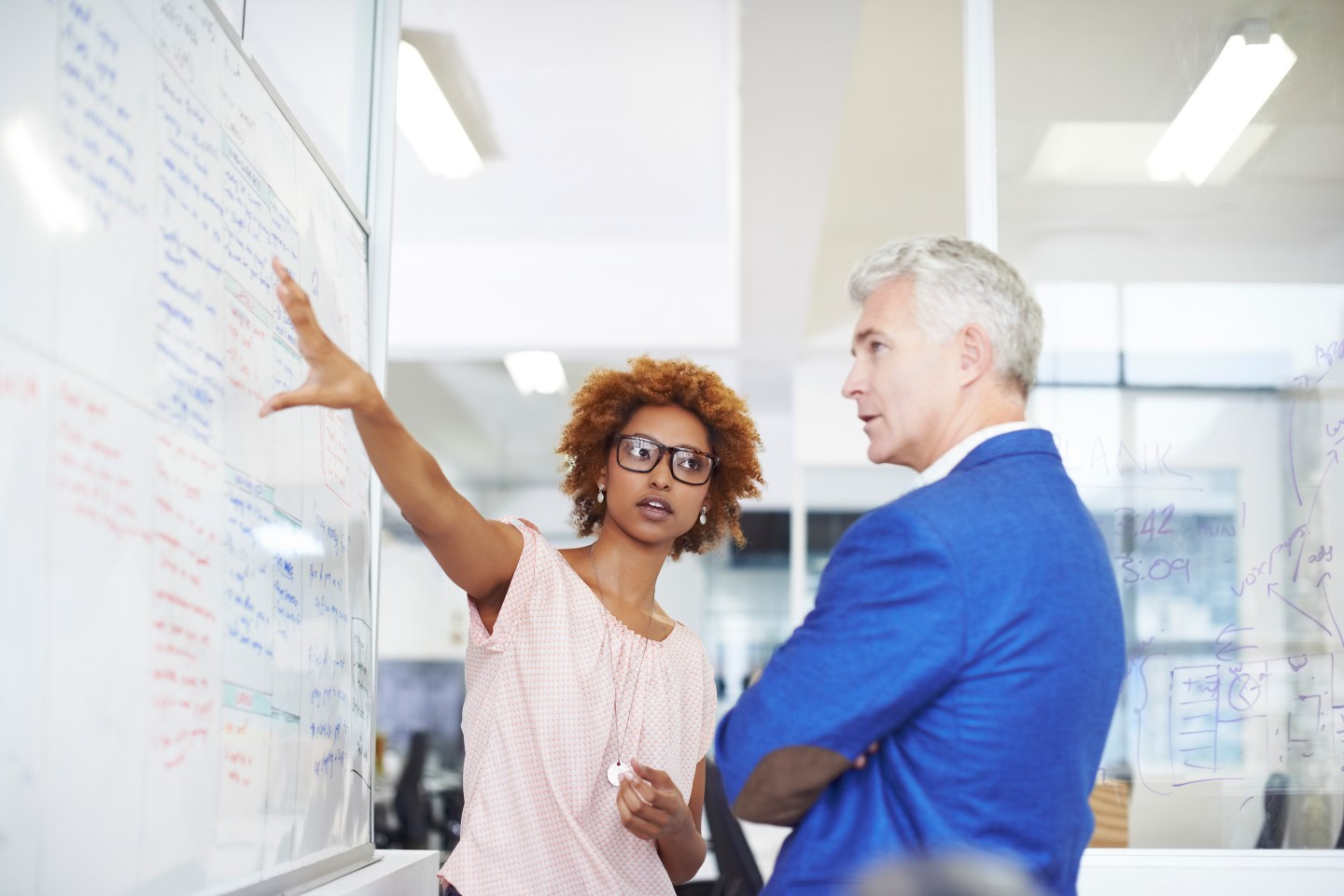 Businesswoman explaining strategy on whiteboard