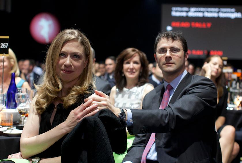 Chelsea Clinton and husband Marc Mezvinsky sit in the audience at the Robin Hood Foundation Benefit at the Jacob K Javits Convention Center in New York
