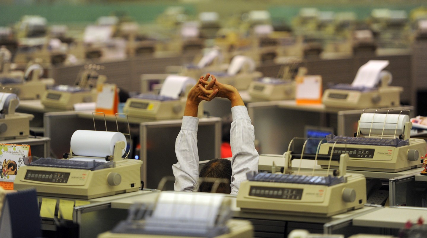 Traders work at the stock exchange in Ho