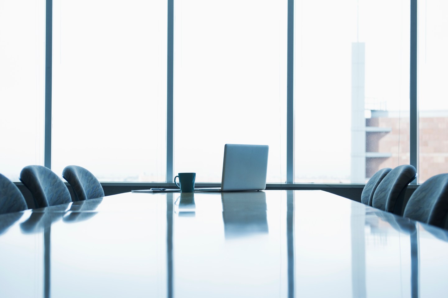 Laptop and coffee cup on conference room table