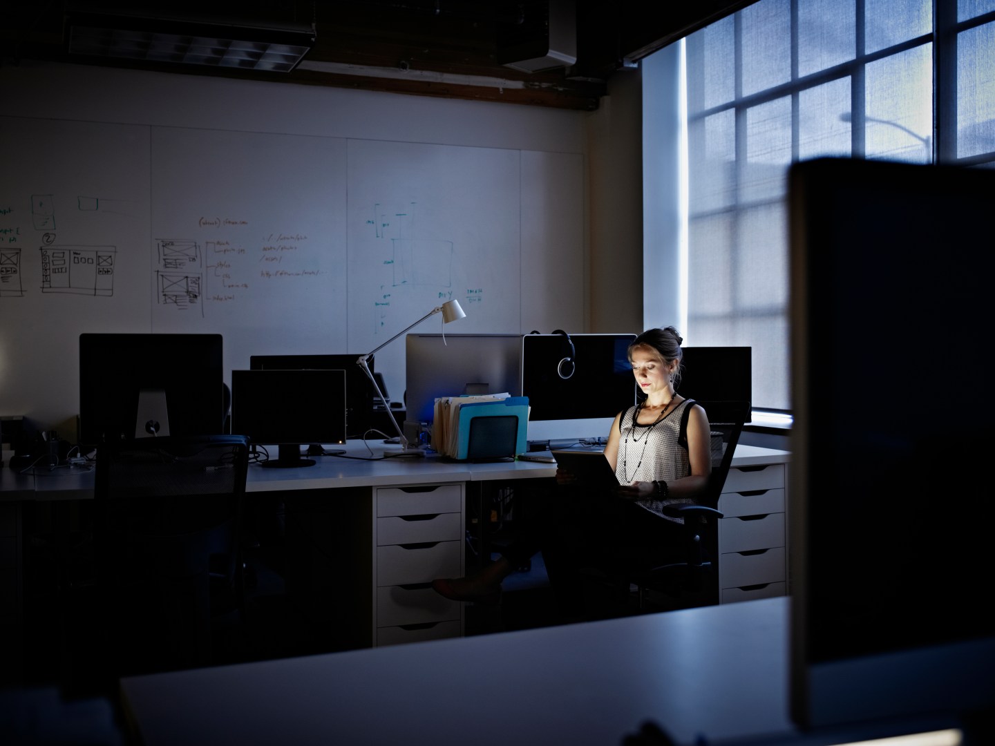 Businesswoman working on digital tablet at night