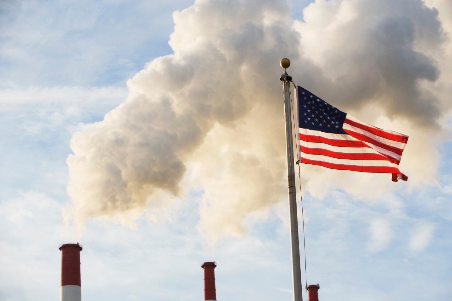 USA, New York State, New York City, American flag in front of smoke stacks