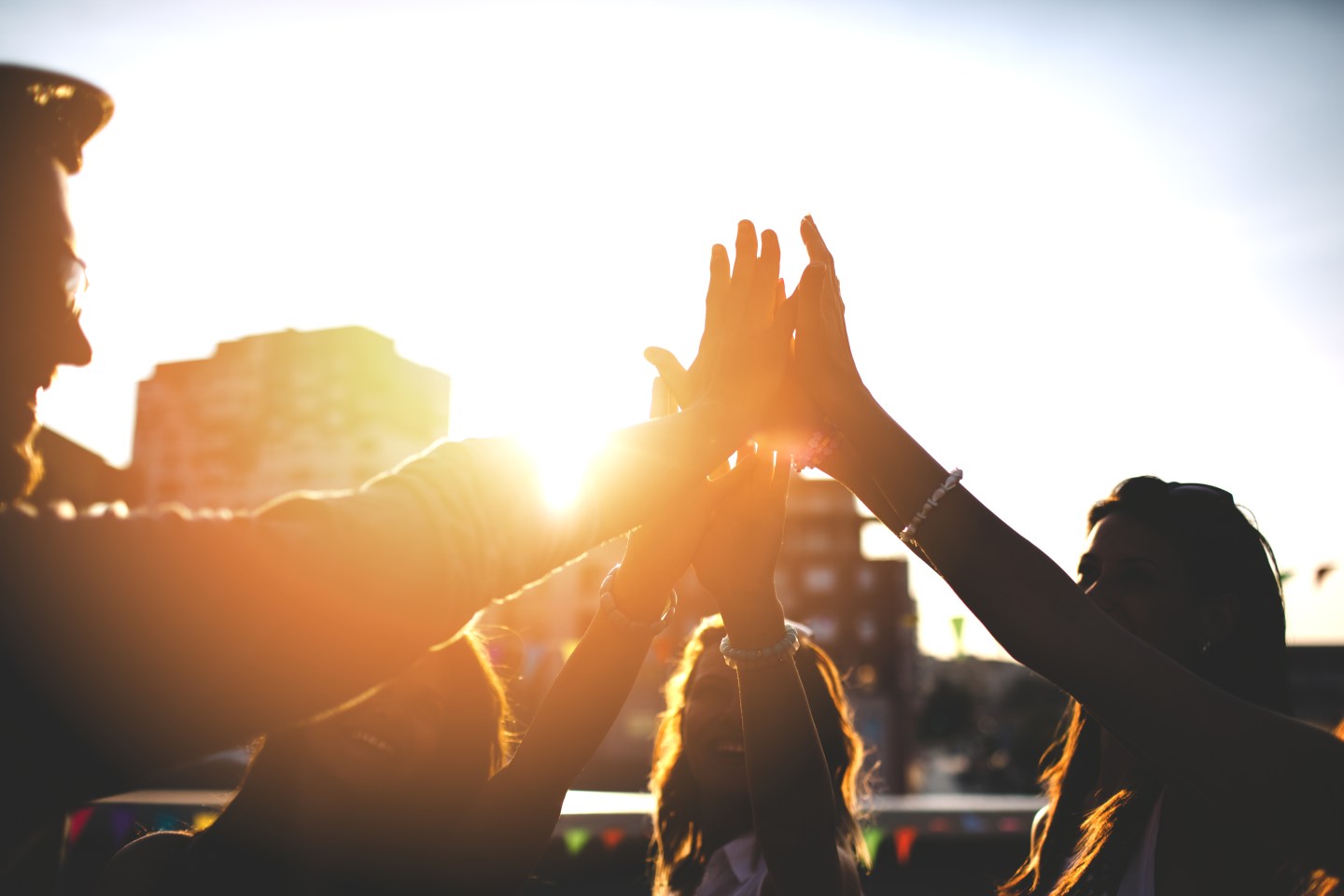 Happy friends at the rooftop doing high five