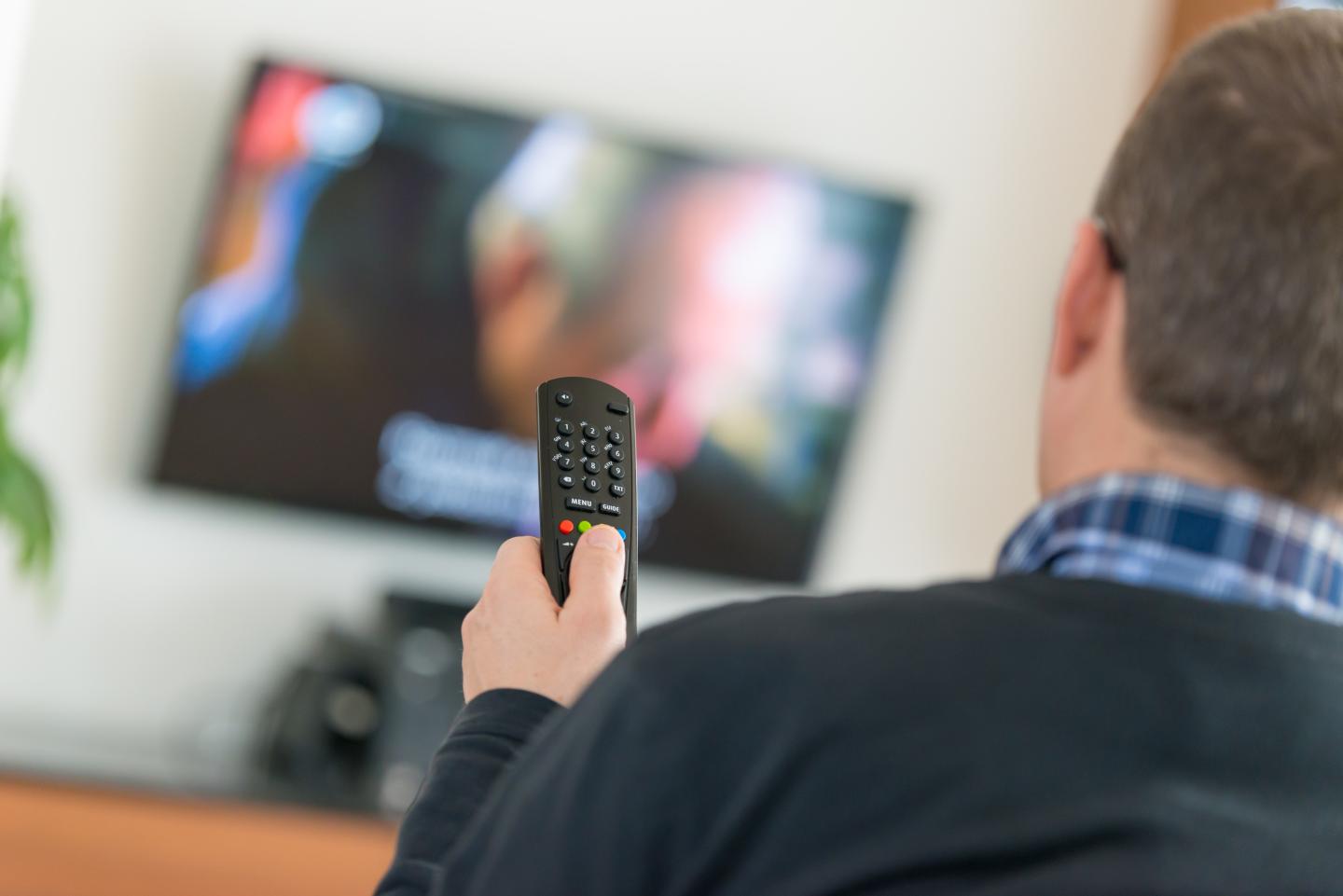 Man using TV Remote Control