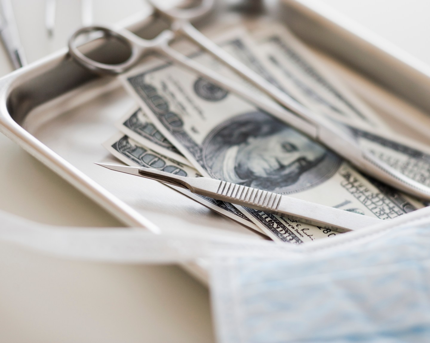 Close up of surgical tools and money