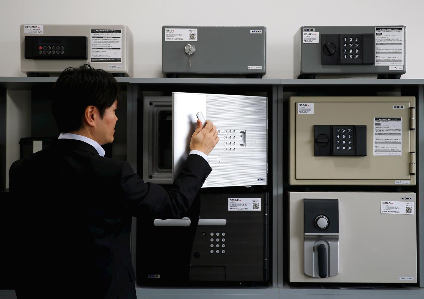 A staff opens a safety deposit box during a photo opportunity at a security showroom in Tokyo