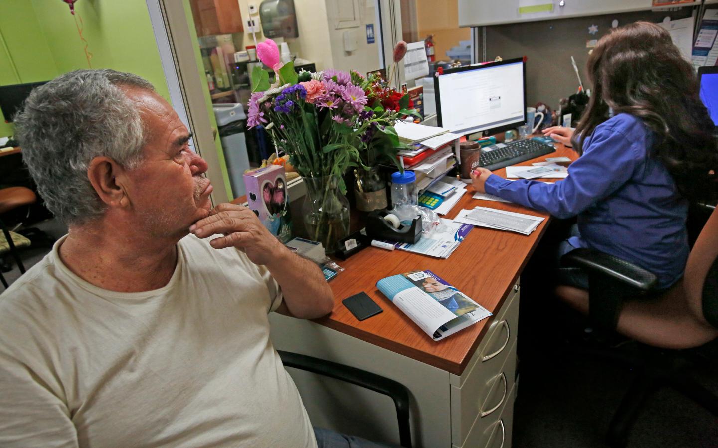 LOS ANGELES, CA. - FEBRUARY 14, 2015: Jose Mora, 62, signs up for Obamacare with Kristie Navarro, ri