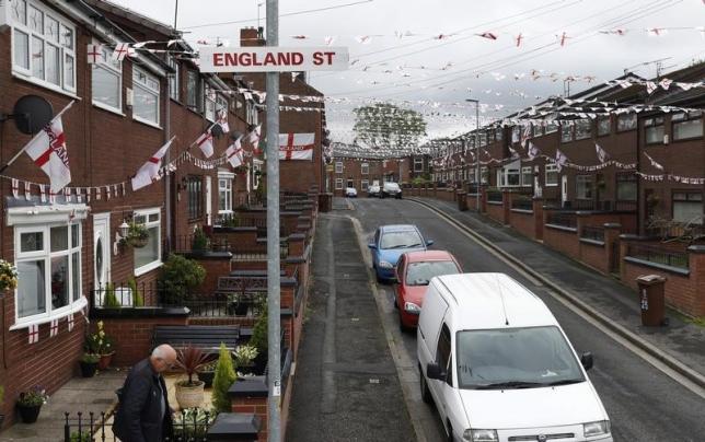A man leaves his home on Wales Street in Oldham, northern England , June 13, 2016. Residents have temporarily renamed the road England Street during the European Soccer championships.