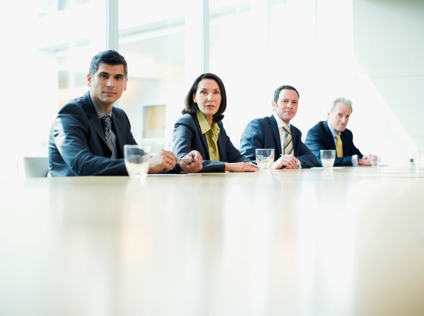 Business people sitting in a row at conference table