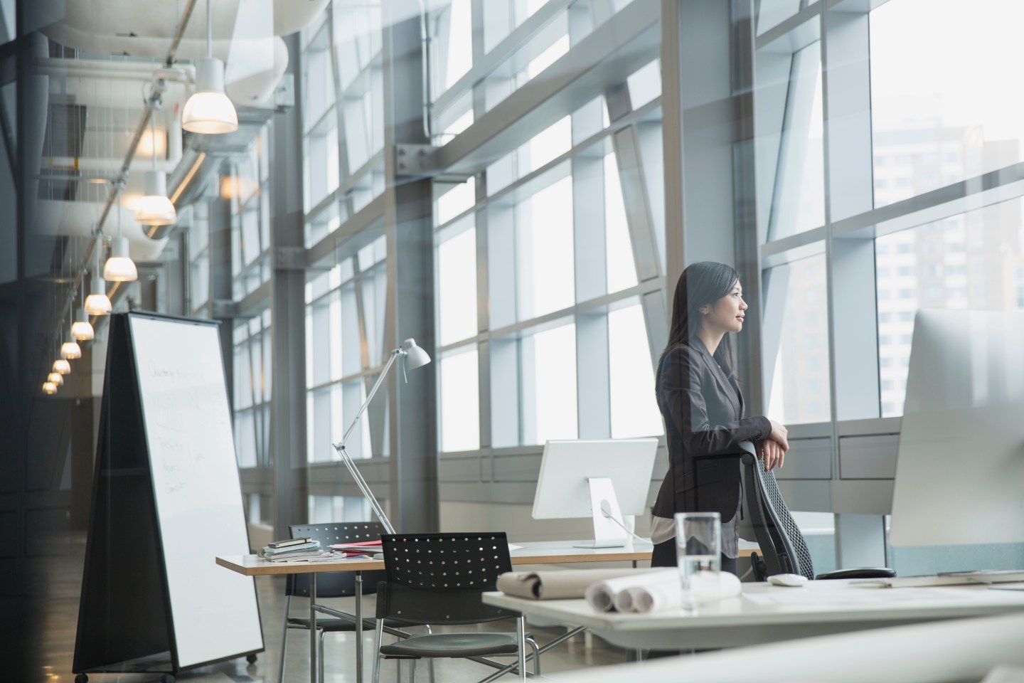 Pensive businesswoman looking out office window