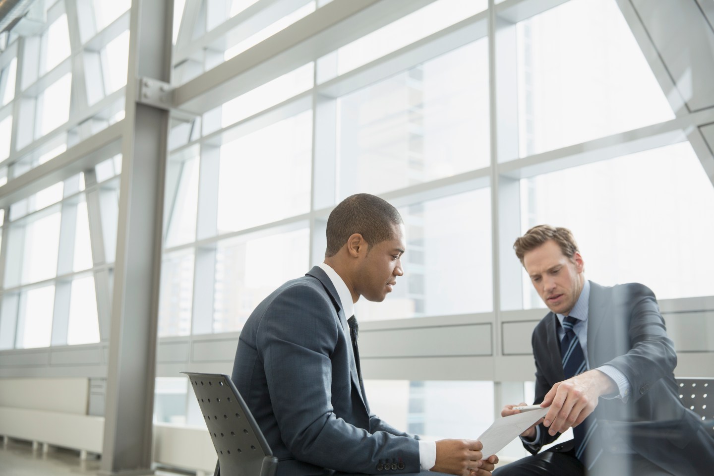 Businessmen discussing paperwork in office