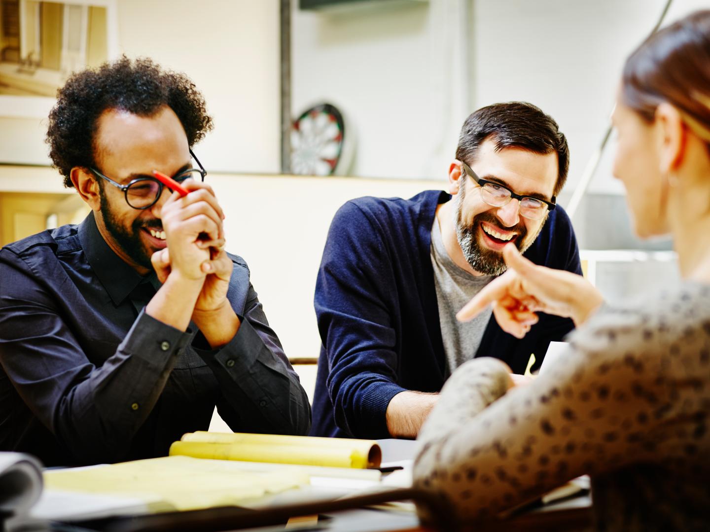 Laughing architects at conference table in office