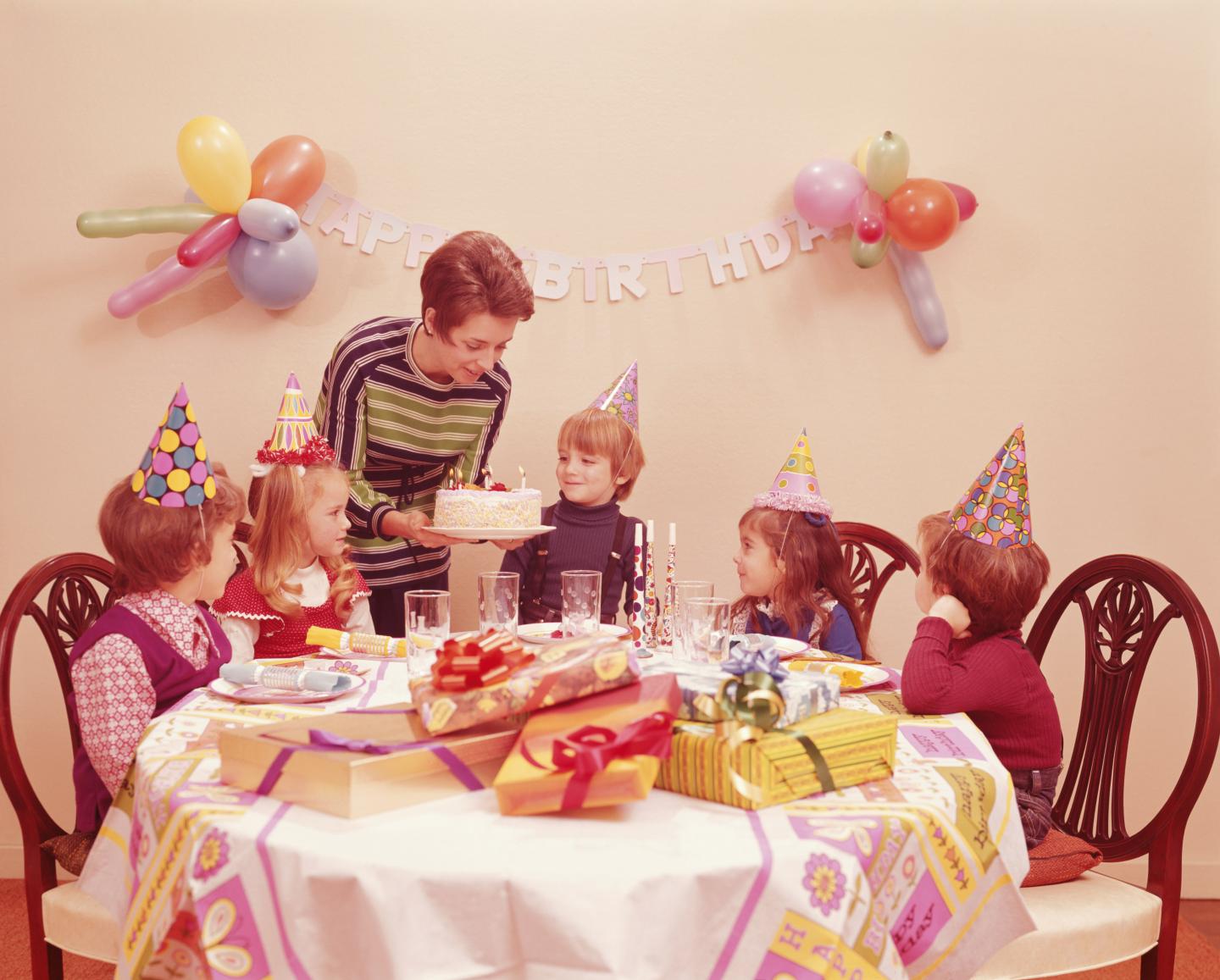 Mother serving birthday cake to children