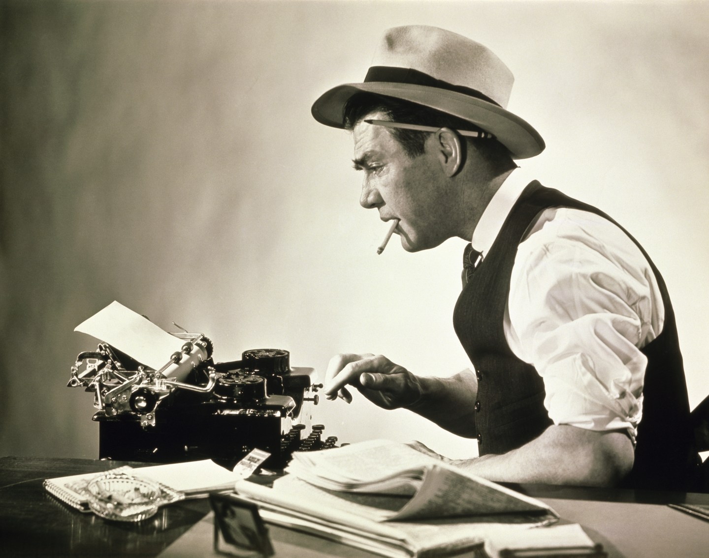 Side profile of a journalist typing on a typewriter