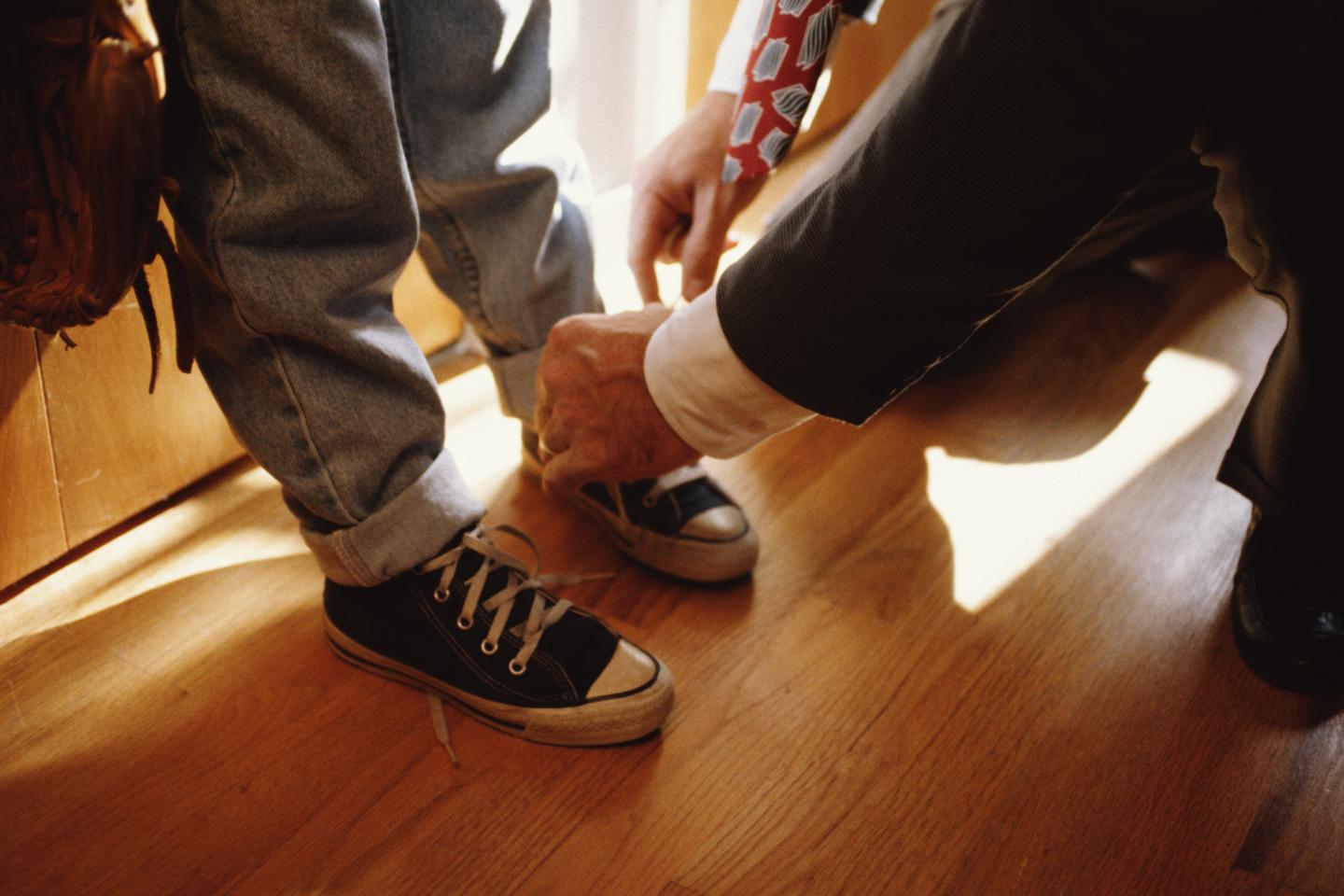 Father tying child's shoelaces