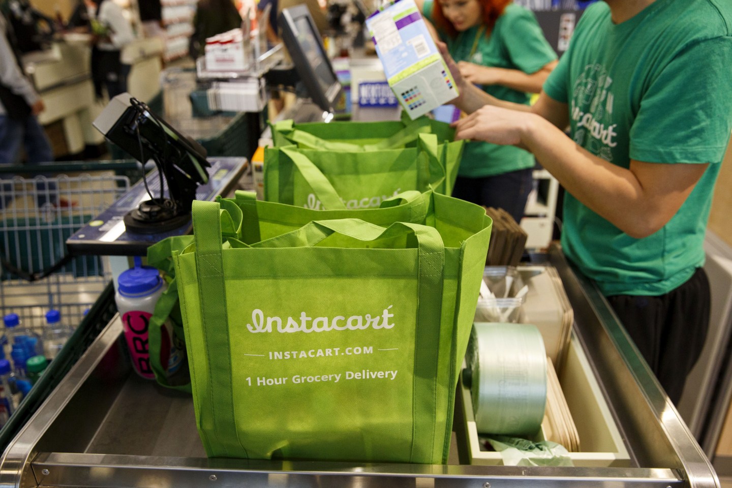 InstaCart employees fulfill orders for delivery at the new Whole Foods Market Inc. store in downtown Los Angeles, California, U.S., on Monday, Nov. 9, 2015. Located beneath the recently opened Eighth &amp; Grand residences, the 41,000-square-foot store features a juice bar, fresh poke, expanded vegan options in all departments, a coffee bar (with cold brew on tap), more than 1,000 hand-picked wines, home delivery via Instacart and bar-restaurant The Eight Bar. Photographer: Patrick T. Fallon/Bloomberg via Getty Images