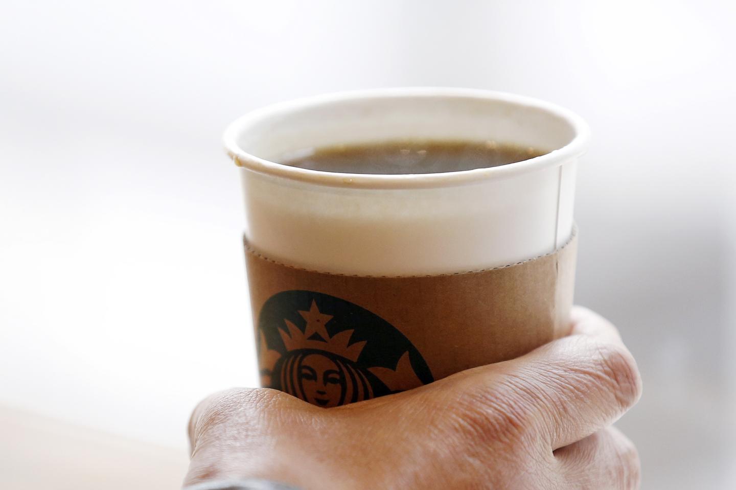 A man holds an Americano at a Starbucks coffee shop in Seoul