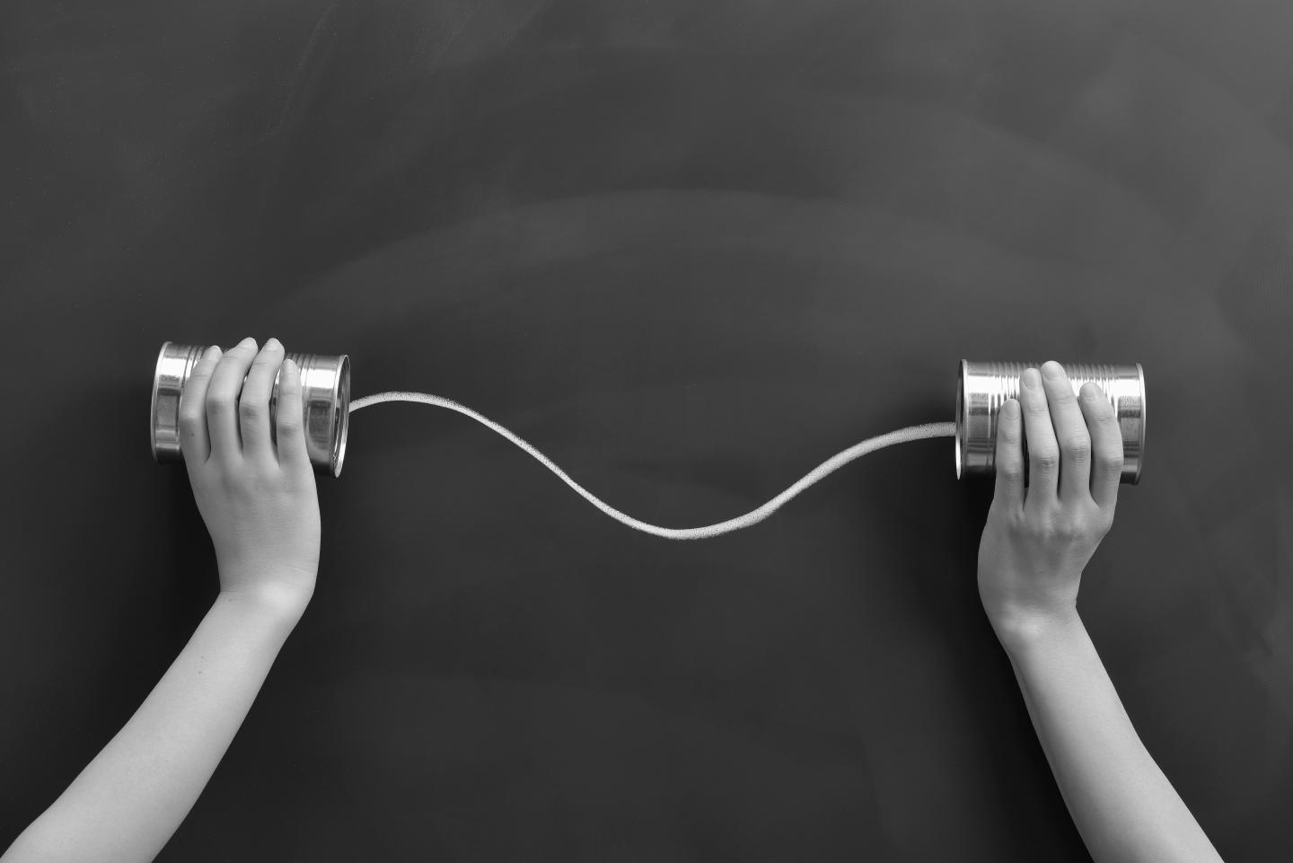 Hands holding the cans on a blackboard