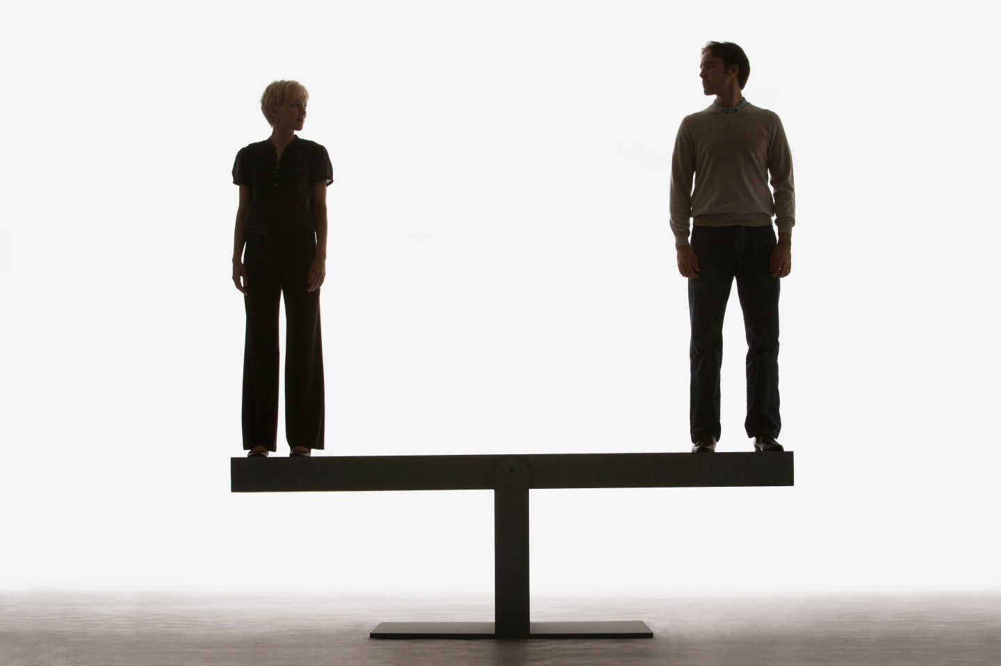 Two people standing on top of a plank