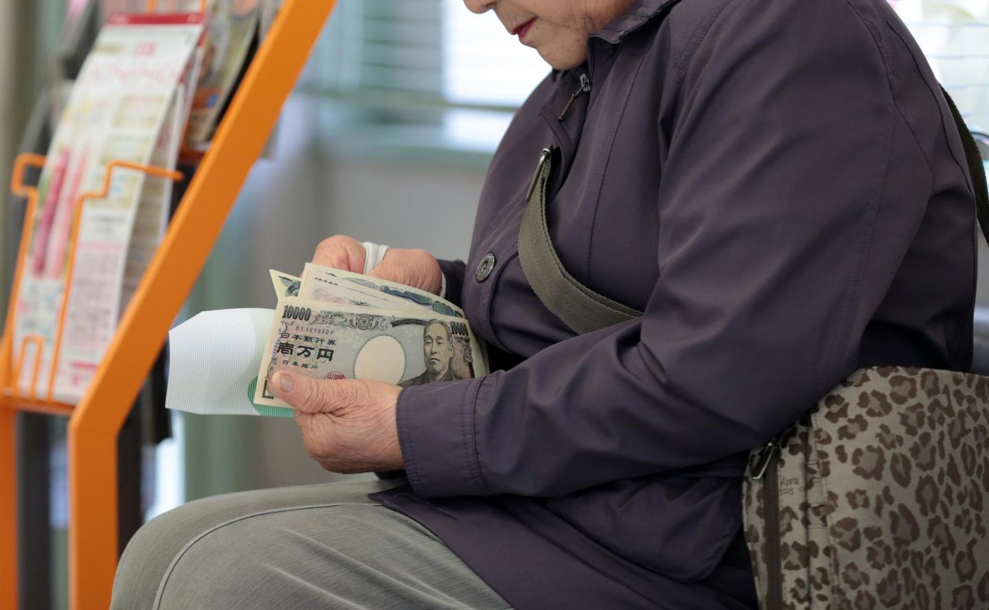 A customer counts her money after making a withdrawal at a