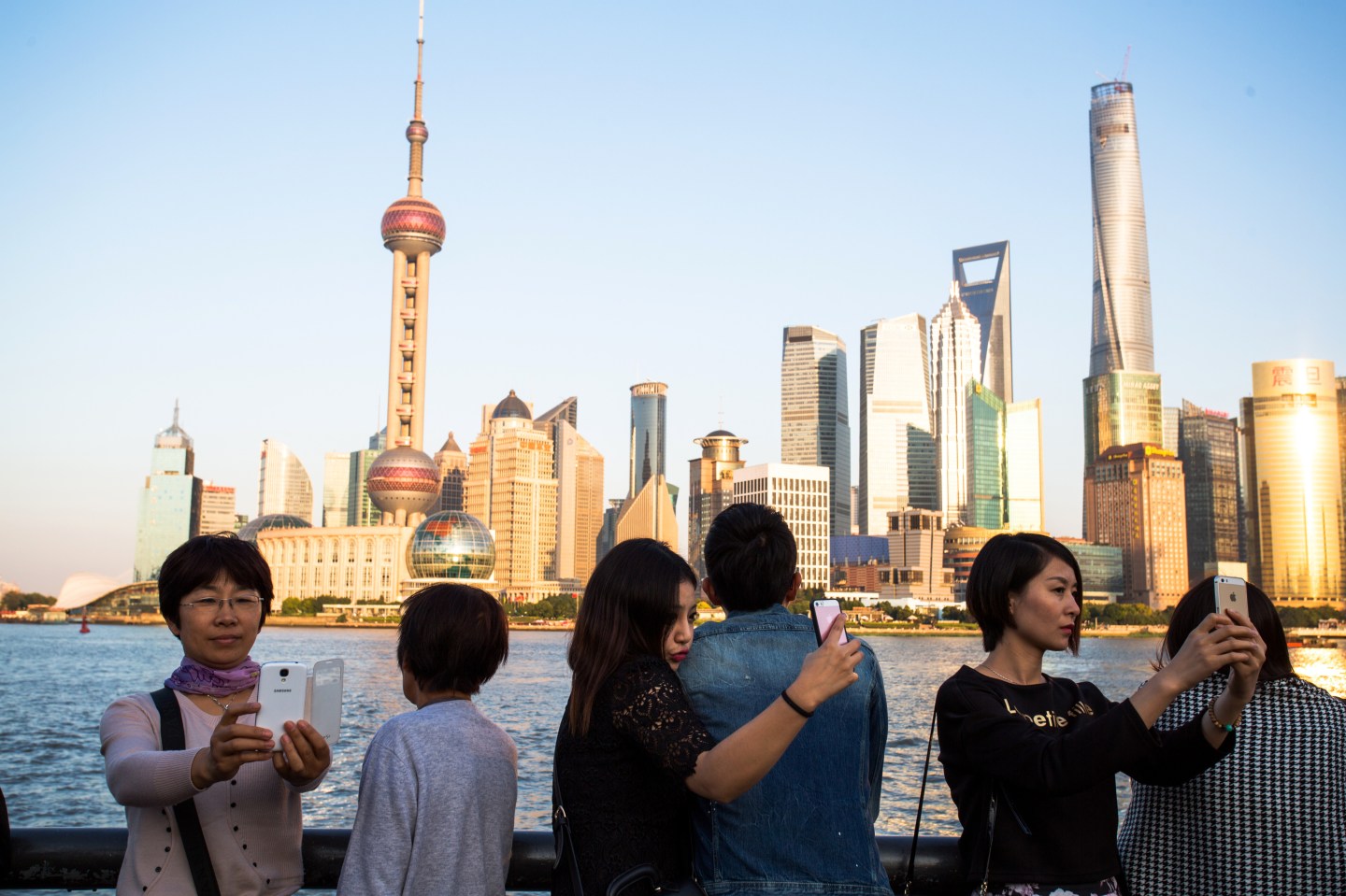 Tourists are taking selfies with the Oriental Pearl tower on