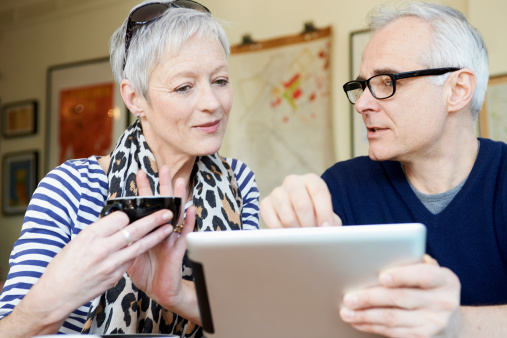 mature man and woman in cafe with digital tablet