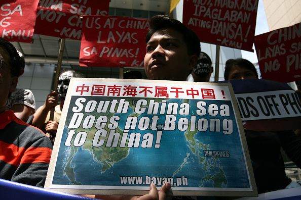 Protesters holding posters against China's incursions in the