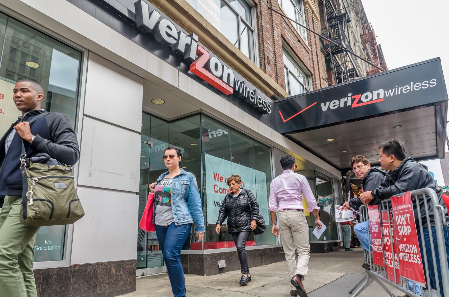 Striking workers on a picket line outside a Verizon retail
