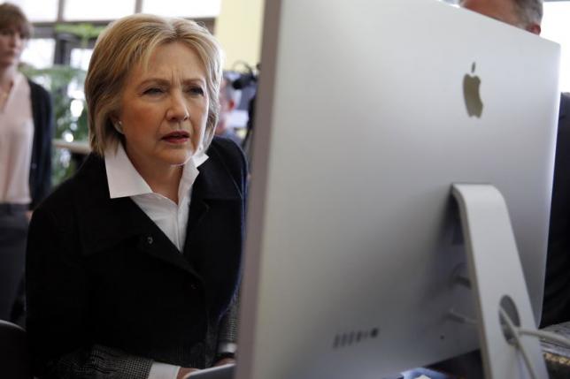 U.S. Democratic presidential candidate Clinton looks at a computer screen during a campaign stop at Atomic Object company in Grand Rapids