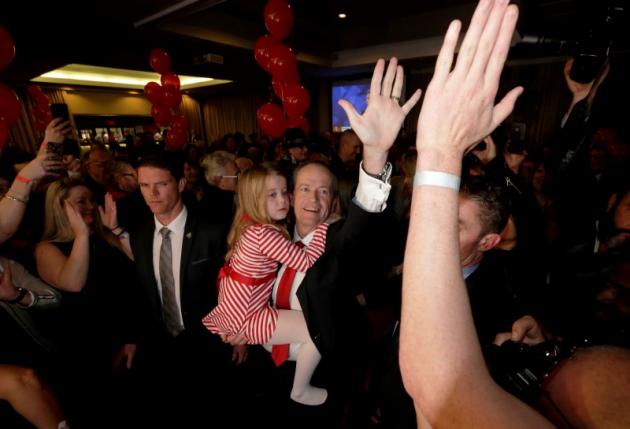 Australian Labor Party opposition leader Bill Shorten high-fives with supporters as he holds his daughter Clementine at his election night party in Melbourne