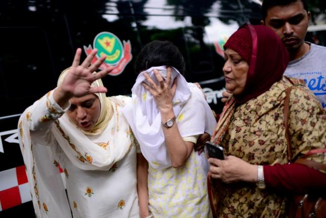 People react near the Holey Artisan restaurant after Islamist militants attacked the upscale cafe in Dhaka